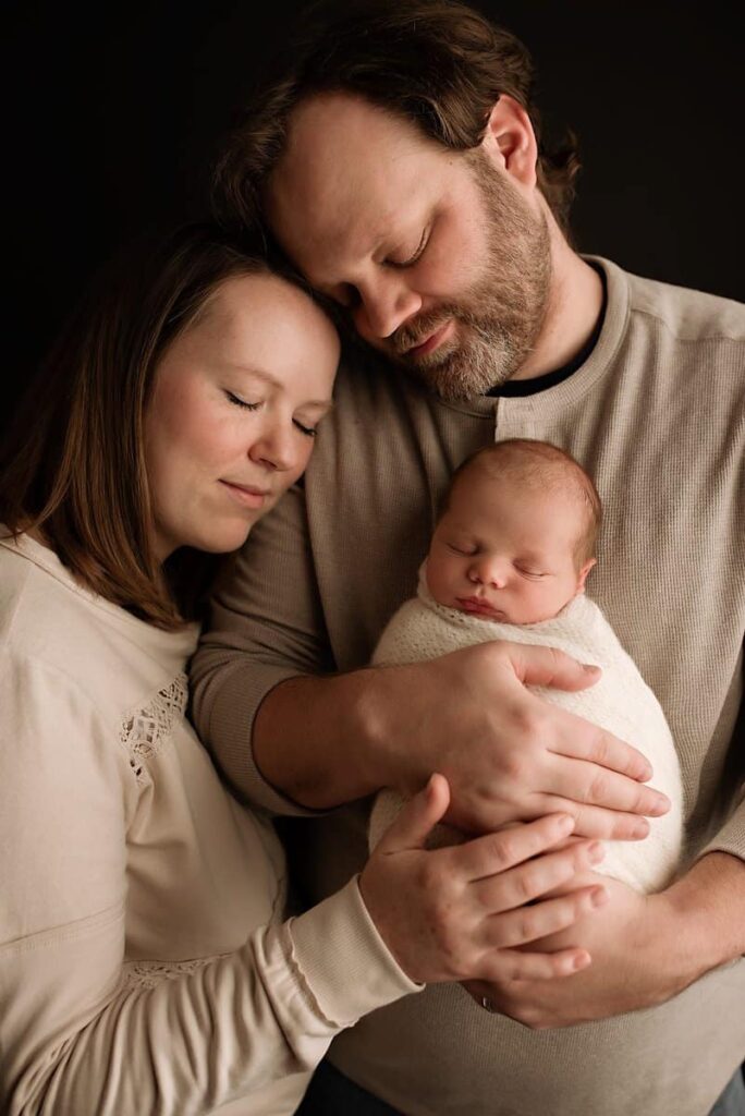 mom and dad snuggled up with their newborn baby boy, newborn with parents photos, newborn photographers near me, atlanta ga baby photographer, marietta newborn photographer, atlanta moms