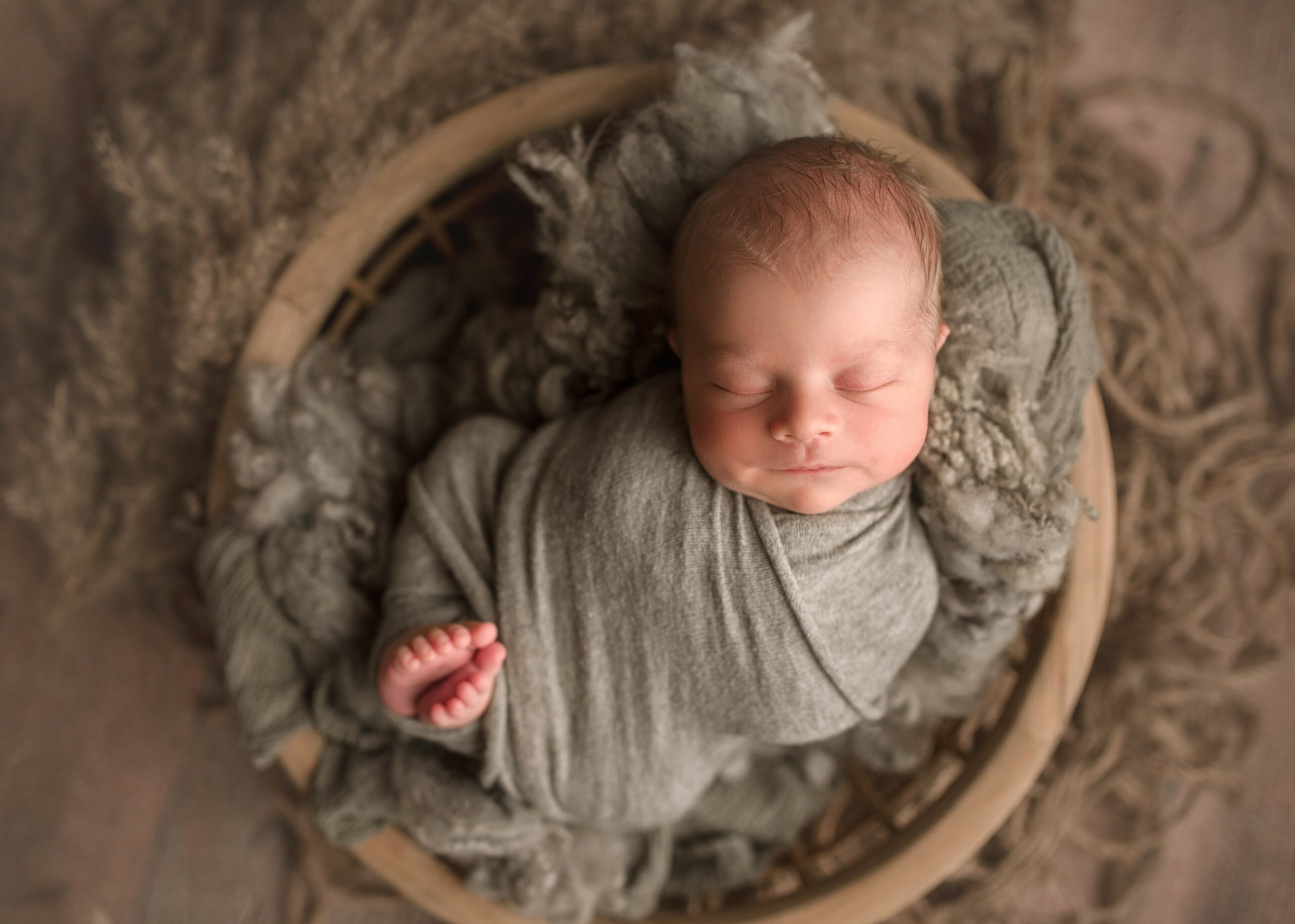 newborn photography lincoln nebraska, newborn boy posed in bowl for photoshoot, newborn photoshoot, best newborn photographer nebraska