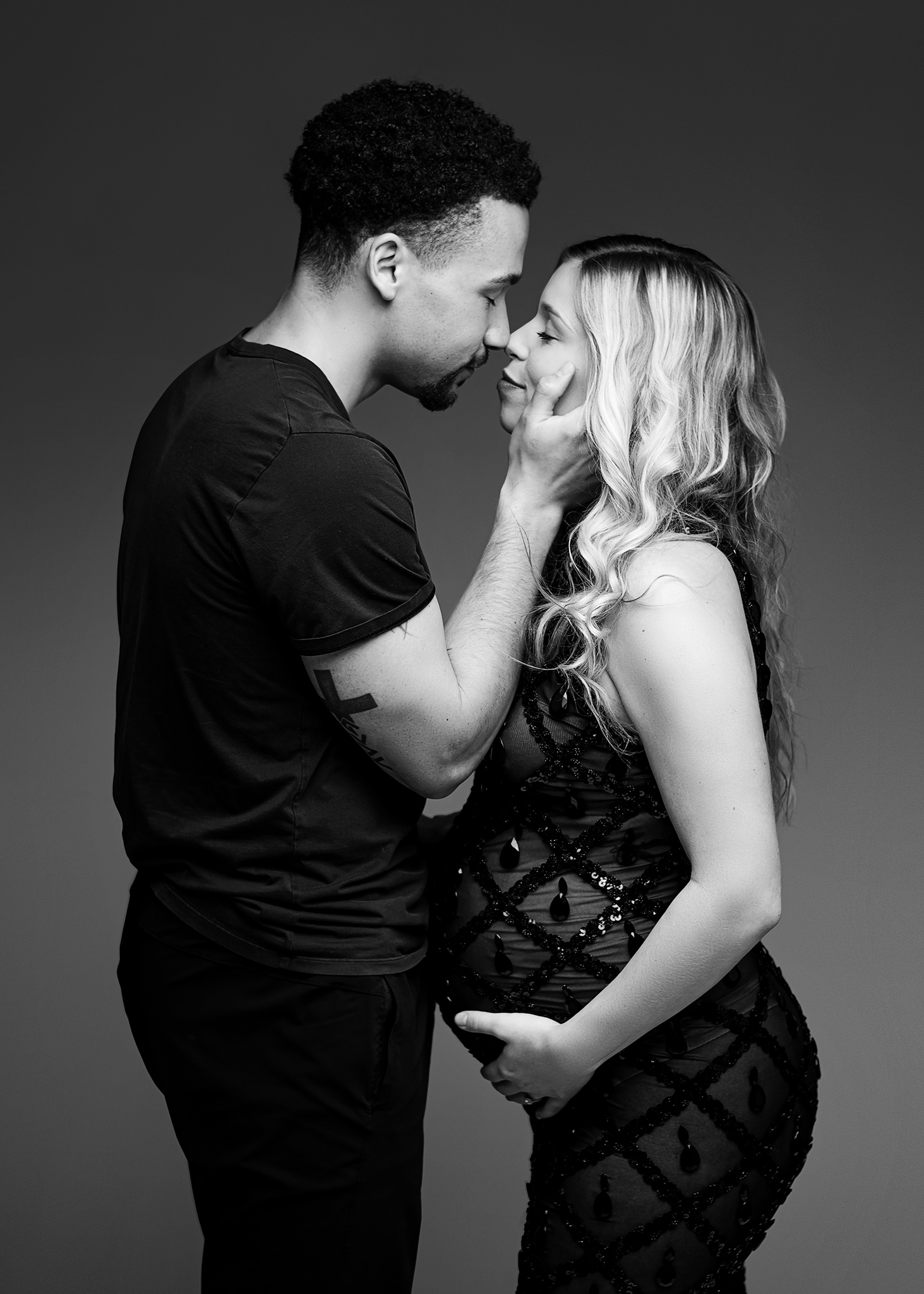 mom and dad facing each other during maternity photoshoot in lincoln ne portrait studio, studio photography lincoln