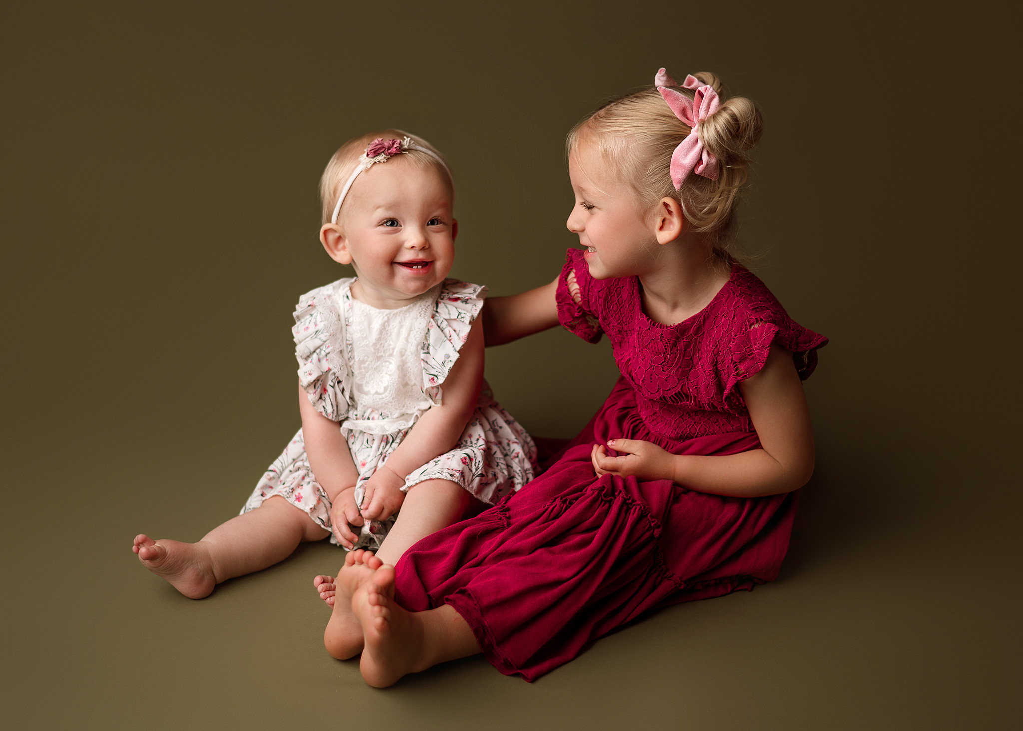 sister photoshoot ideas, studio photography nebraska, sisters posed on solid backdrop for photoshoot