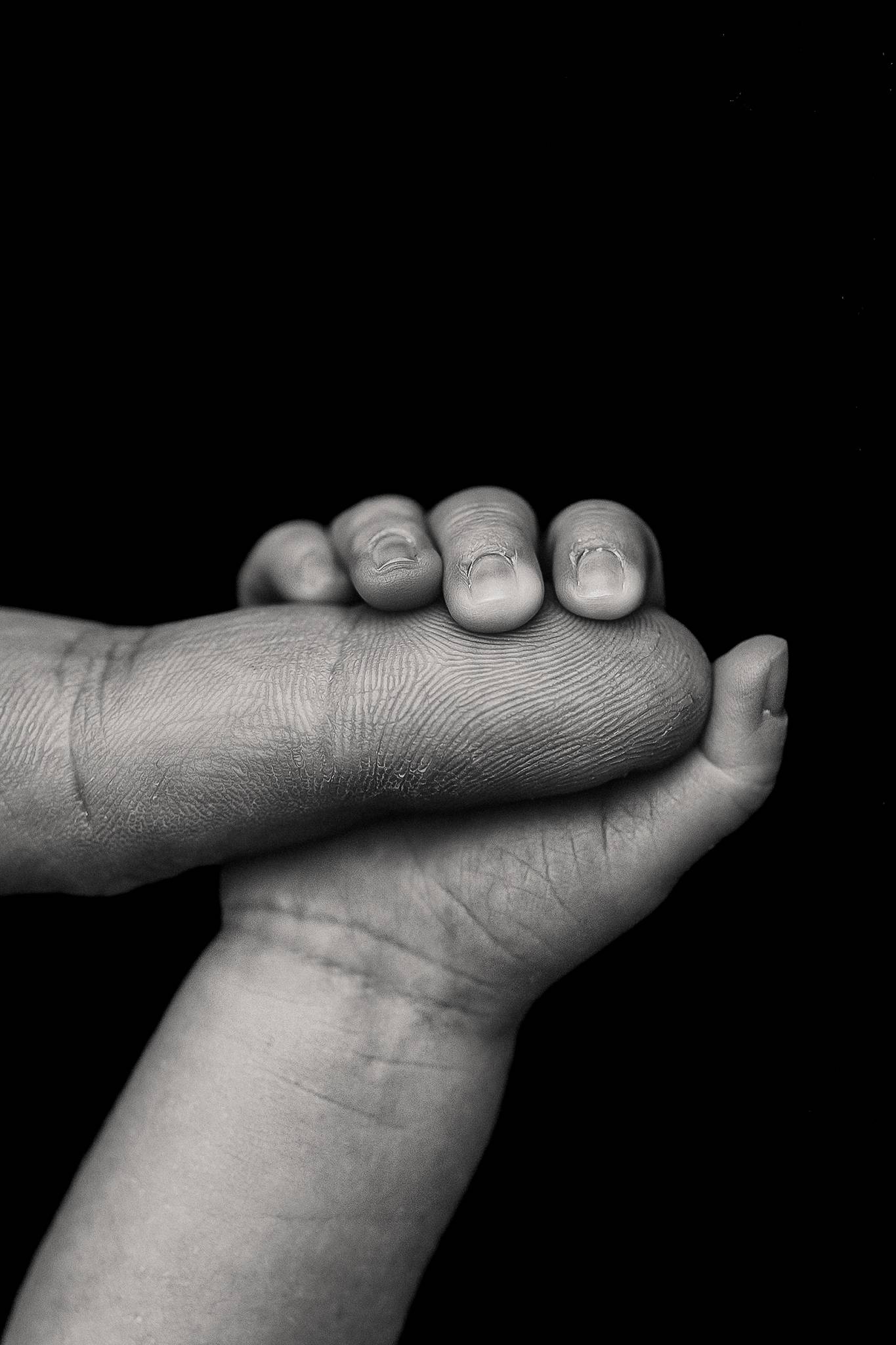 newborn holding his dads finger during newborn photography session in nebraska, nebraska newborn photographer, comfort nursing