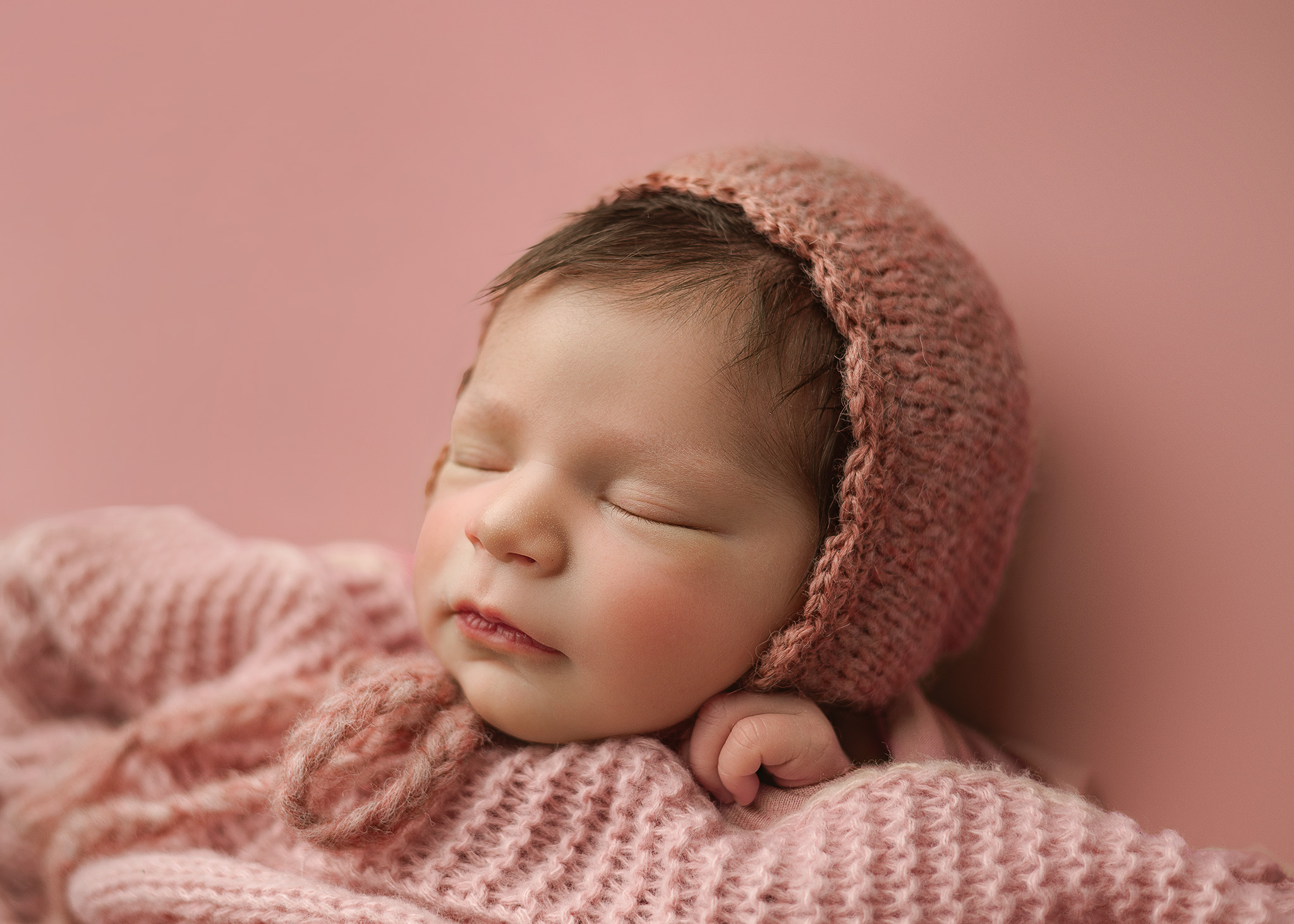 babygirl with a knit bonnet photographed in lincoln nebraska studio