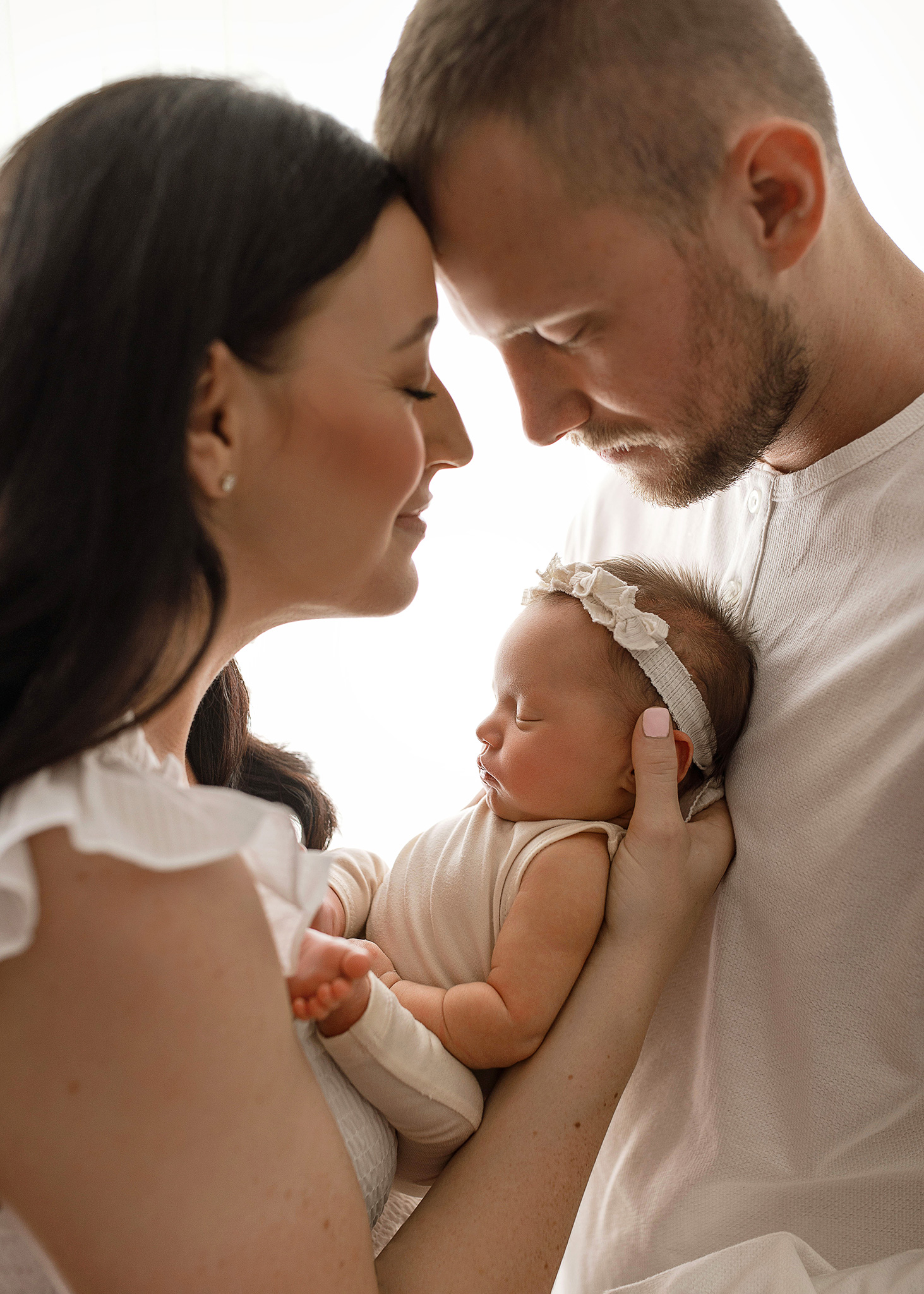 mom and dad posing with newborn baby girl in lincoln nebraska photography studio, Luxury photography studio, fine art portraits